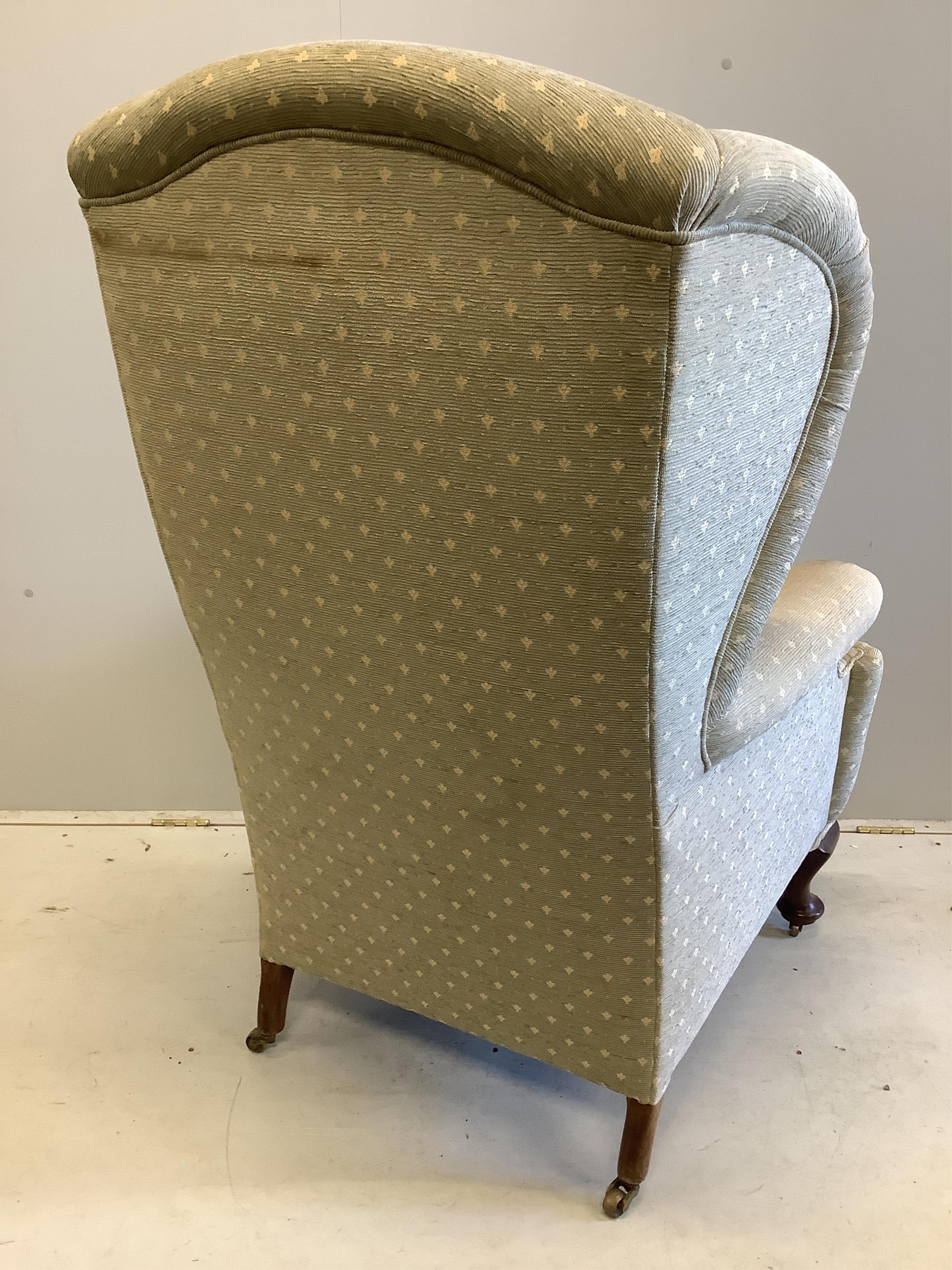 An early 20th century upholstered wing armchair, width 80cm, depth 80cm, height 124cm. Condition - fair